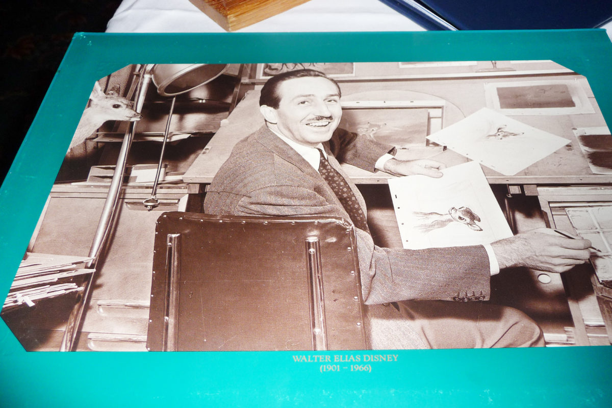 Image shows the inside of the menu at walts restaurant in disneyland paris. There is a photo of walt animating and holding a drawing of bambi.