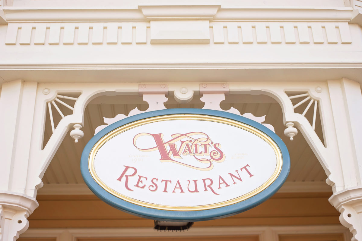 Image shows Walt's Restaurant sign on main street in disneyland paris. 