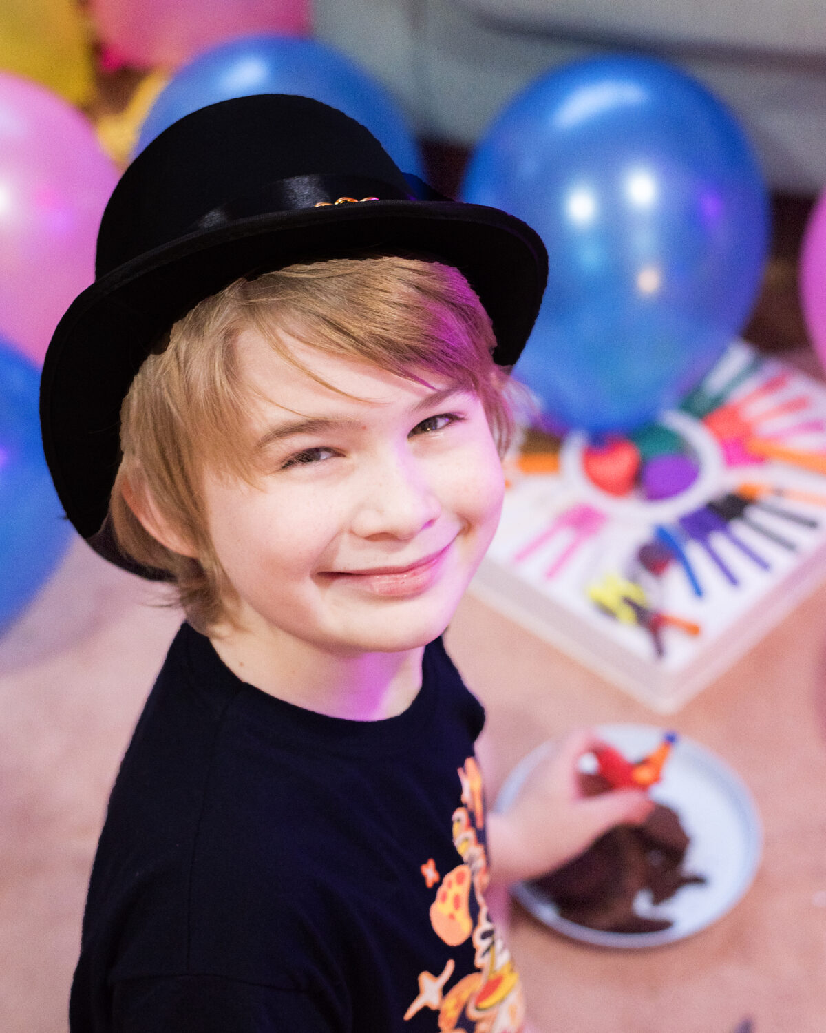 Image shows a happy boy smiling at the camera with a black top hat on. image by keep up with the jones family.