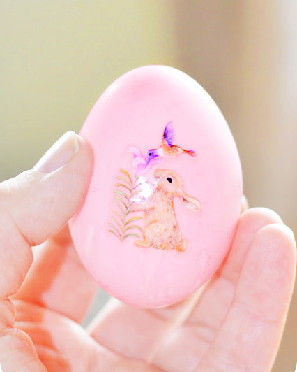 Image shows pink coloured duck egg, hollowed for easter. The candy pink easter egg has a sticker of a real rabbit  and some flowers.
