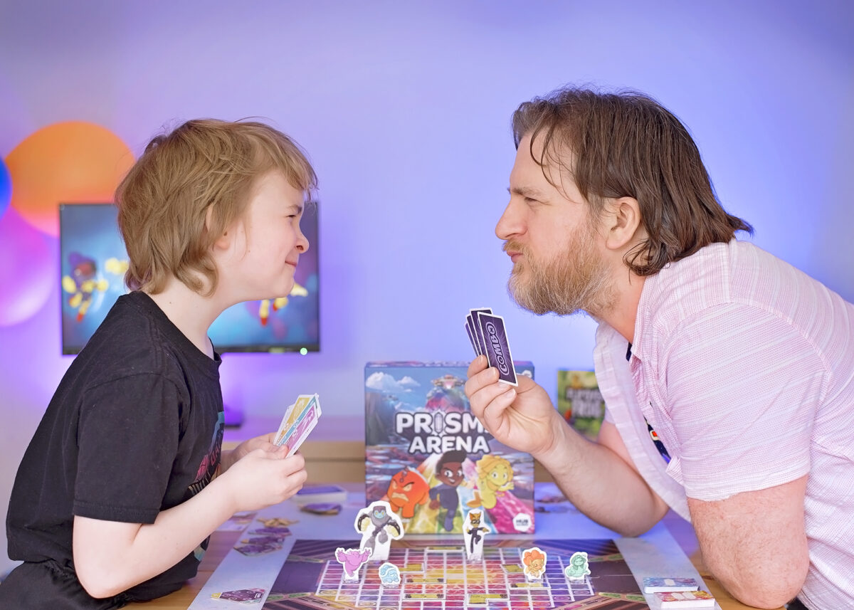 How to win Prisma Arena. Photo shows Dad and son head to head holding combo cards in their hands.  