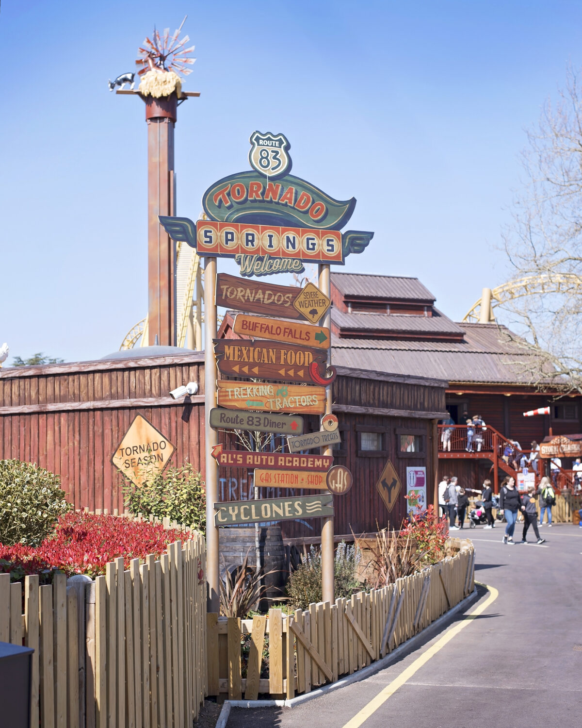 Image shows a directional signpost in Paultons Park Tornado Springs. Made of wood, the names of the rides in the theme park are listed on each arrow.