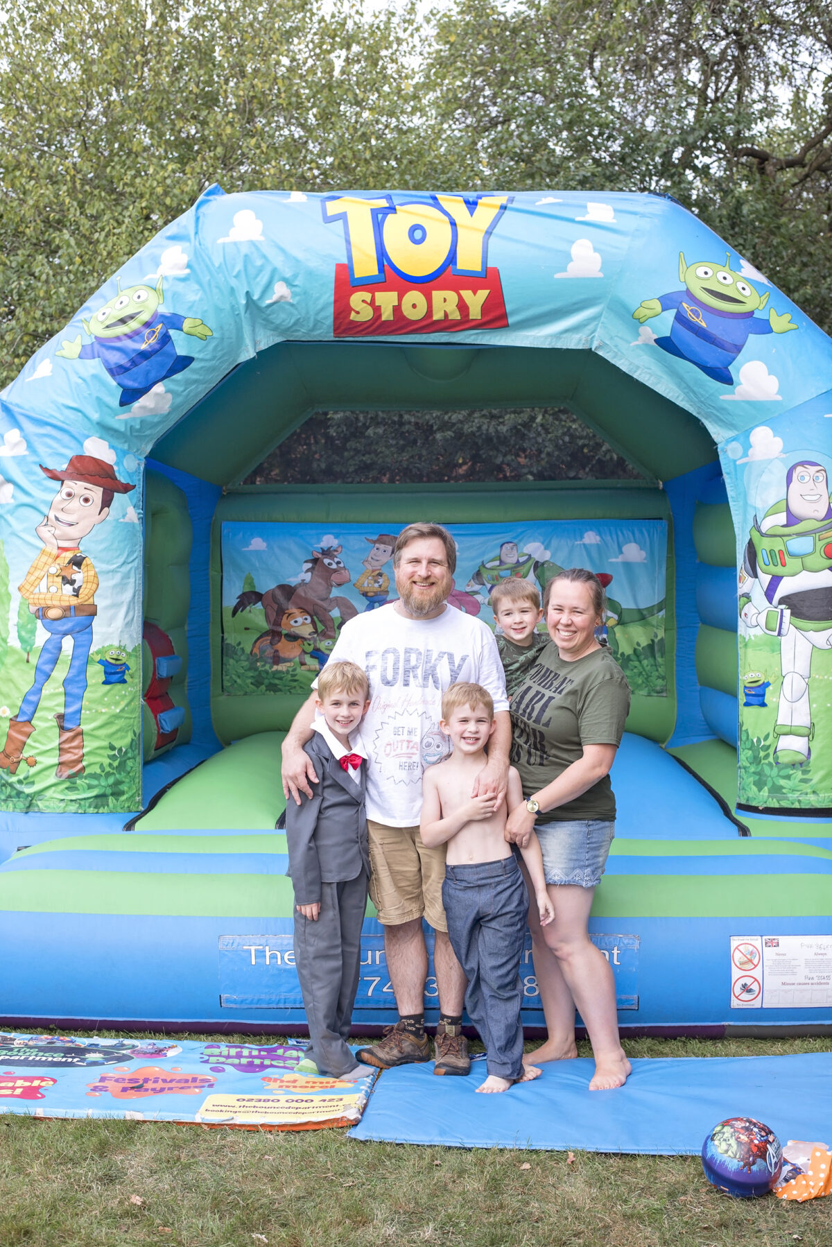 Image shows a toy story inflatable castle and a the Jones family stood next to it.