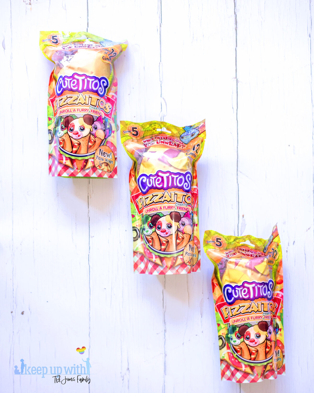 Cuteitos Pizzaitos. Image shows three Cuteitos Pizzaitos in their wrappers on a white wooden background. 