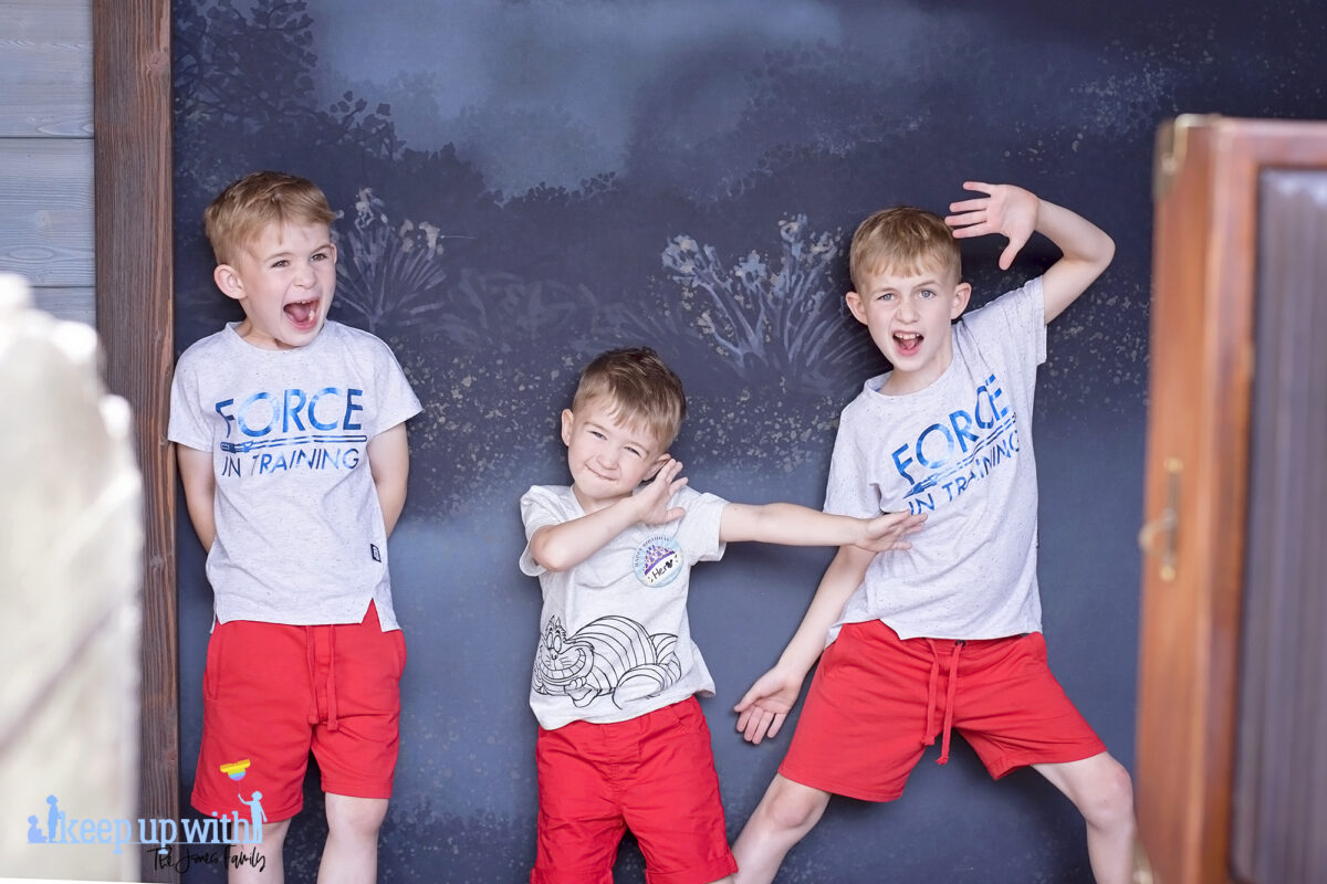 Image shows three little boys dressed in red shorts and star wars t-shirts posing in the Disneyland Paris Spirit Photography Booth where you can print a personalised copy of the Mysterious Chronicle by Phantom Manor. Image by Keep Up With The Jones Family.
