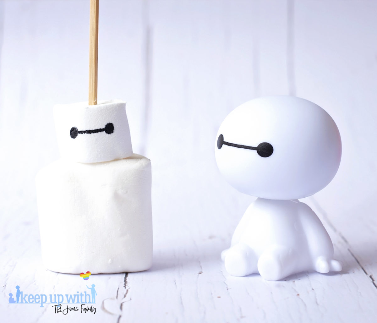 Image shows a plastic Baymax figure from Disney Pixar's Big Hero 6, and a Marshmallow Bayman Pop sat next to it on a white tabletop. Image by Keep Up With the Jones Family